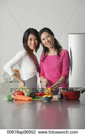 Mother and adult daughter in kitchen, looking at camera View Large Photo Image Stock Image - Mother and adult daughter in kitchen, looking at camera. Fotosearch