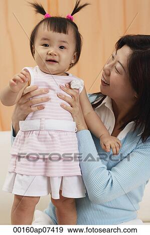 mother and baby girl, mother looking at girl, girl looking at camera View Large Photo Image Stock Photo - mother and baby girl, mother looking at girl, girl looking at camera. Fotosearch