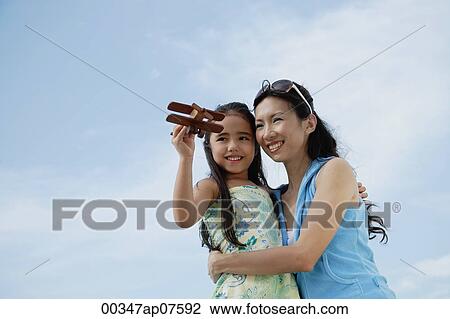 Mother and daughter flying wooden airplane, mother holding daughter View Large Photo Image Stock Image - Mother and daughter flying wooden airplane, mother holding daughter. Fotosearch