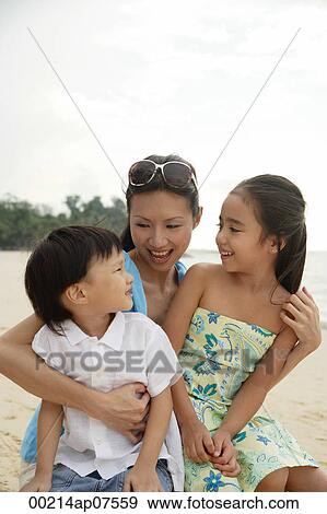 Mother, daughter and son sitting on beach together View Large Photo Image Stock Photo - Mother, daughter and son sitting on beach together. Fotosearch