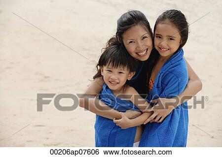 Mother, son and daughter on beach, kids wrapped in blue towel, mother hugging children View Large Photo Image Stock Photograph - Mother, son and daughter on beach, kids wrapped in blue towel, mother hugging children. Fotosearch