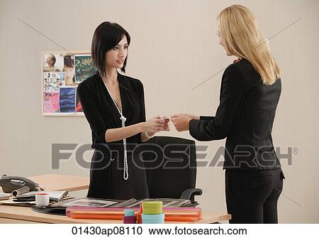One woman gives another her business card View Large Photo Image Stock Image - One woman gives another her business card. Fotosearch
