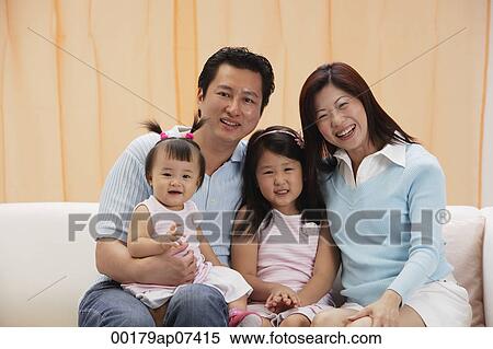 portrait of Family of 4, mom, dad and two daughters, sitting on couch, smiling, looking at camera View Large Photo Image Stock Photography - portrait of Family of 4, mom, dad and two daughters, sitting on couch, smiling, looking at camera. Fotosearch