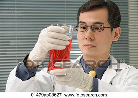 Scientist examining container of fluid View Large Photo Image Stock Photo - Scientist examining container of fluid. Fotosearch