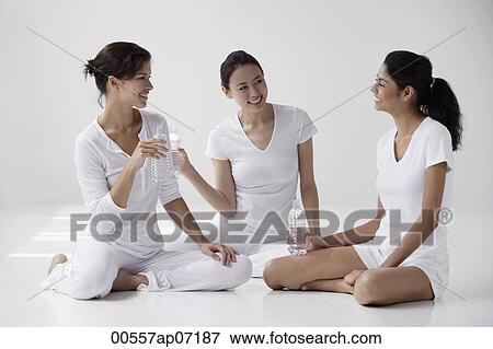 three women of mixed race sitting on floor holding water and talking View Large Photo Image Stock Photo - three women of mixed race sitting on floor holding water and talking. Fotosearch