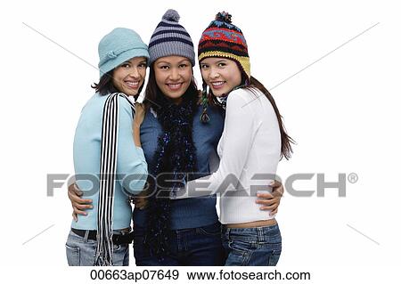 Stock Photo - Three women wearing hats and scarves, smiling at camera. Fotosearch