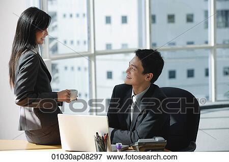 Two colleagues smile as they talk to each other View Large Photo Image Stock Photo - Two colleagues smile as they talk to each other. Fotosearch