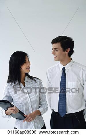 Stock Photograph - Two colleagues smile at each other. Fotosearch
