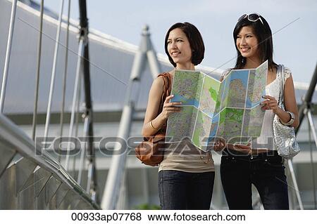Stock Photo - Two friends check a map together. Fotosearch