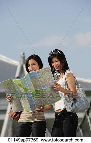 Stock Photo - Two friends check a map together. Fotosearch