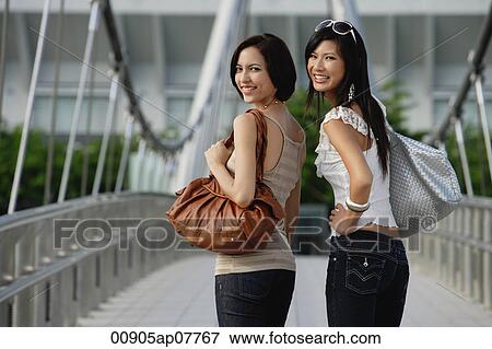 Two friends walk across a bridge together View Large Photo Image Stock Photo - Two friends walk across a bridge together. Fotosearch