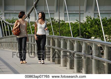 Two friends walk across a bridge together View Large Photo Image Stock Photography - Two friends walk across a bridge together. Fotosearch