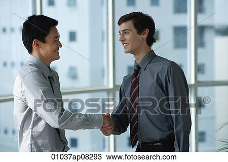 Two male colleagues shake hands View Large Photo Image Stock Image - Two male colleagues shake hands. Fotosearch