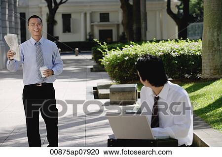 Two men greet each other in the park View Large Photo Image Stock Image - Two men greet each other in the park. Fotosearch
