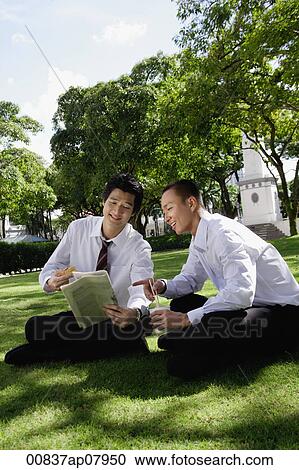 Two men read the newspaper in the park View Large Photo Image Stock Image - Two men read the newspaper in the park. Fotosearch