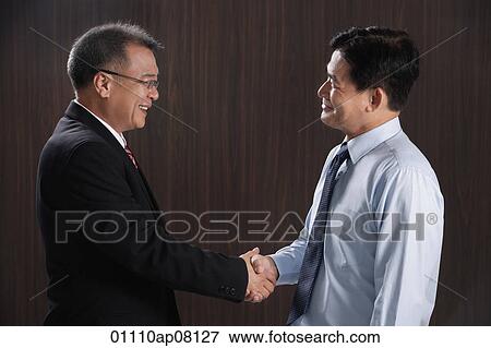 Two men smile and shake hands View Large Photo Image Stock Photo - Two men smile and shake hands. Fotosearch