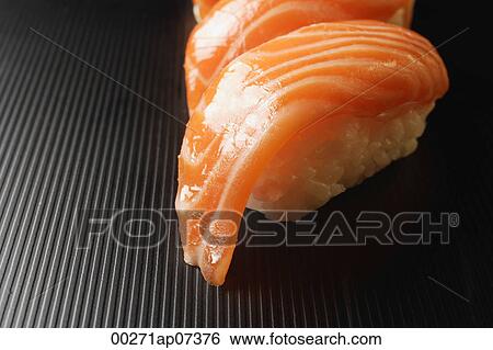 Stock Photograph - two pieces of salmon sushi, nigiri on rice ball. Fotosearch