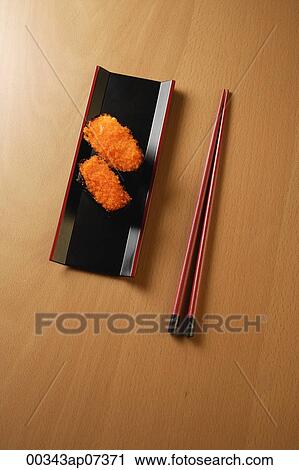 two pieces of sushi, chopsticks, tobiko gunkan, fish roe View Large Photo Image Stock Image - two pieces of sushi, chopsticks, tobiko gunkan, fish roe. Fotosearch
