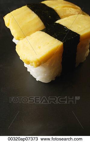 Two pieces of sushi, Tam ago Nigeria, sweet Japanese egg omelettes on sushi rice ball View Large Photo Image Stock Image - Two pieces of sushi, Tam ago Nigeria, sweet Japanese egg omelettes on sushi rice ball. Fotosearch