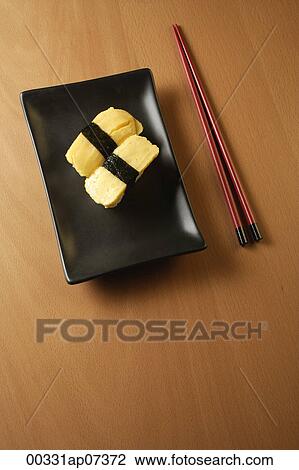 Two pieces of sushi, Tam ago Nigeria, sweet Japanese egg omelettes on sushi rice ball, chopsticks View Large Photo Image Stock Image - Two pieces of sushi, Tam ago Nigeria, sweet Japanese egg omelettes on sushi rice ball, chopsticks. Fotosearch