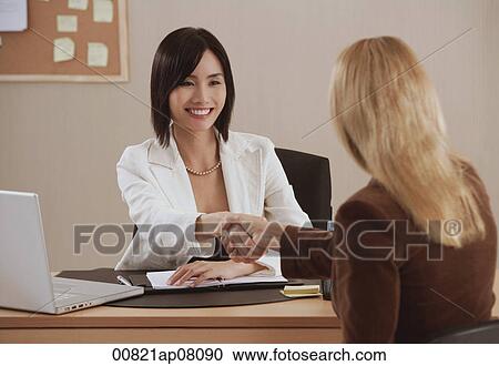 Two woman shake hands at work View Large Photo Image Stock Image - Two woman shake hands at work. Fotosearch