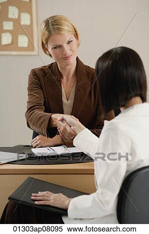 Two woman shake hands at work View Large Photo Image Stock Photography - Two woman shake hands at work. Fotosearch