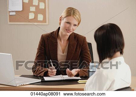 Two woman talk together at work View Large Photo Image Stock Image - Two woman talk together at work. Fotosearch