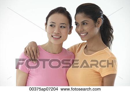 Two women looking away from camera, smiling View Large Photo Image Picture - Two women looking away from camera, smiling. Fotosearch