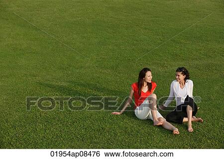 Two women relaxing in the park View Large Photo Image Stock Photograph - Two women relaxing in the park. Fotosearch
