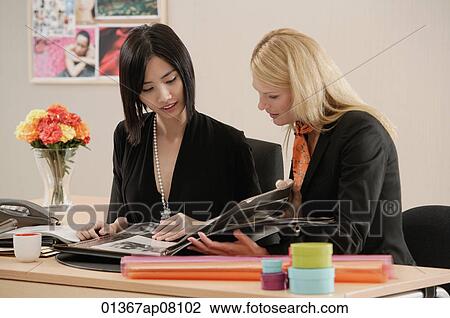 Two women working together View Large Photo Image Stock Image - Two women working together. Fotosearch