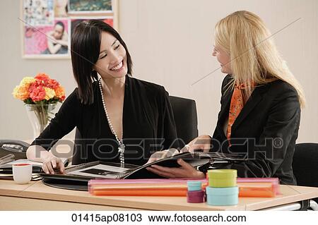 Two women working together View Large Photo Image Stock Image - Two women working together. Fotosearch