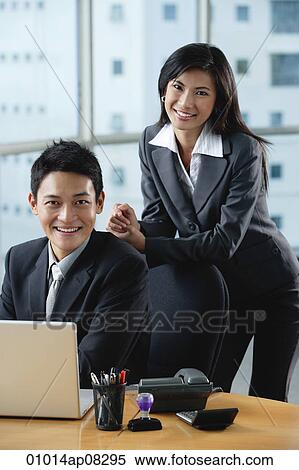Two work colleagues smile at the camera together View Large Photo Image Stock Photography - Two work colleagues smile at the camera together. Fotosearch