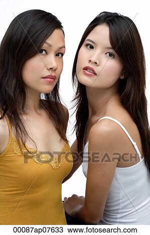 Stock Image - Two young women looking at camera, beauty. Fotosearch