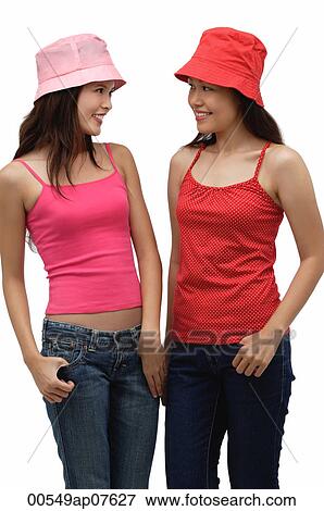 two young women wearing red and pink, looking at each other View Large Photo Image Stock Photo - two young women wearing red and pink, looking at each other. Fotosearch
