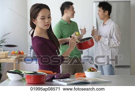 Woman cooking while men talk View Large Photo Image Stock Image - Woman cooking while men talk. Fotosearch