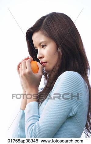 Woman holding orange View Large Photo Image Stock Photo - Woman holding orange. Fotosearch