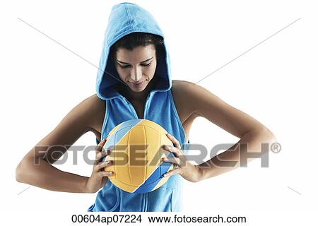 Woman holding volley ball, looking at ball, wearing hood, sports View Large Photo Image Picture - Woman holding volley ball, looking at ball, wearing hood, sports. Fotosearch