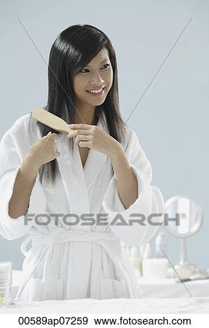 woman in bathrobe, brushing hair and smiling View Large Photo Image Stock Photo - woman in bathrobe, brushing hair and smiling. Fotosearch