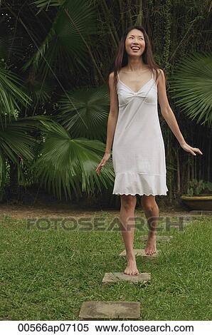 Woman in garden, walking on stepping stones, smiling, looking up View Large Photo Image Stock Photography - Woman in garden, walking on stepping stones, smiling, looking up. Fotosearch
