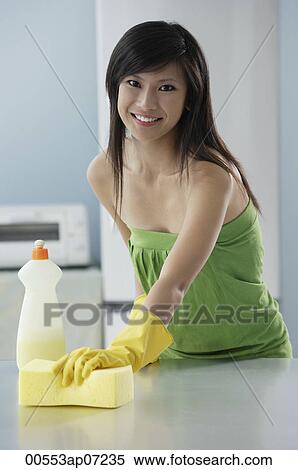 woman in kitchen cleaning counter with sponge, smiling at camera View Large Photo Image Stock Photography - woman in kitchen cleaning counter with sponge, smiling at camera. Fotosearch