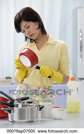 Woman in kitchen, cleaning pots and pans View Large Photo Image Stock Photography - Woman in kitchen, cleaning pots and pans. Fotosearch
