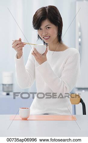 Woman in kitchen, holding bowl and chopsticks View Large Photo Image Stock Photograph - Woman in kitchen, holding bowl and chopsticks. Fotosearch