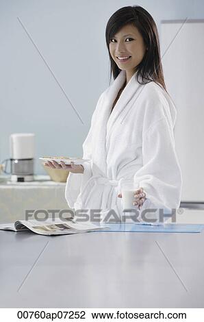 woman in kitchen, holding glass of milk and plate of cookies, smiling at camera View Large Photo Image Stock Image - woman in kitchen, holding glass of milk and plate of cookies, smiling at camera. Fotosearch