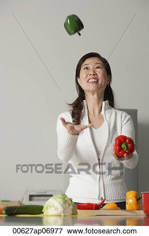 Woman in kitchen, juggling vegetables View Large Photo Image Stock Photo - Woman in kitchen, juggling vegetables. Fotosearch