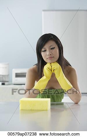 woman in kitchen, looking at sponge, thinking, cleaning View Large Photo Image Stock Photo - woman in kitchen, looking at sponge, thinking, cleaning. Fotosearch