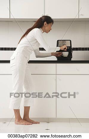 Woman in kitchen making coffee, cappuccino View Large Photo Image Stock Image - Woman in kitchen making coffee, cappuccino. Fotosearch