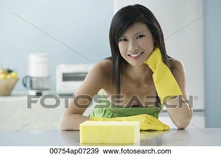 woman in kitchen with sponge, wearing gloves, looking at camera, smiling View Large Photo Image Stock Photo - woman in kitchen with sponge, wearing gloves, looking at camera, smiling. Fotosearch