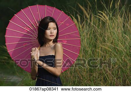 Woman in long grass with parasol View Large Photo Image Stock Image - Woman in long grass with parasol. Fotosearch