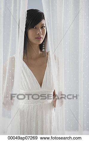 woman in white dress, looking through curtains at camera View Large Photo Image Stock Photo - woman in white dress, looking through curtains at camera. Fotosearch