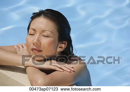 Woman leaning at the edge of swimming pool, arms crossed, eyes closed View Large Photo Image Stock Image - Woman leaning at the edge of swimming pool, arms crossed, eyes closed. Fotosearch